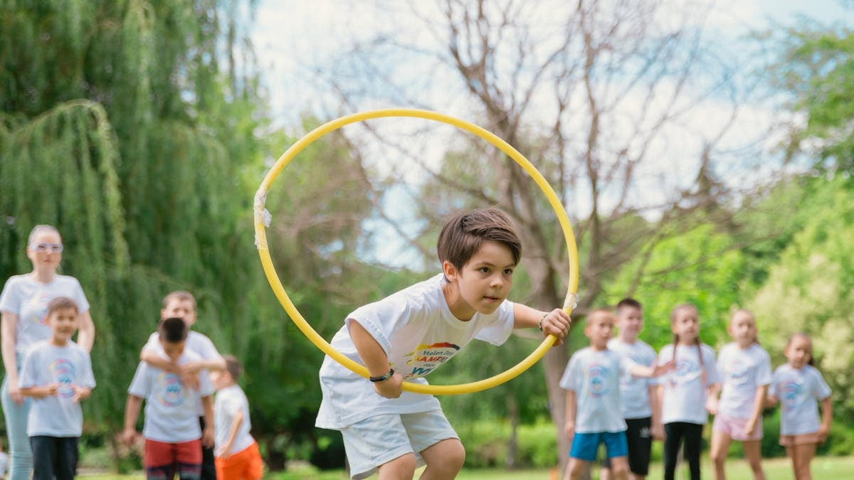 Kids enjoying a summer day playing with hula hoops in a park, showcasing friendship and fun.